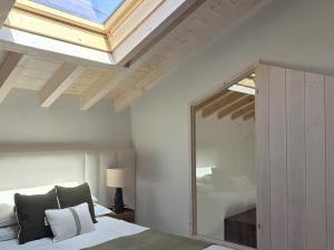 a bedroom with a skylight and a bed with a mirror at La Casuca del Olivo - casa con jardín cerca de Cabárceno y Santander in Ceceñas