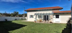 a white house with a patio with chairs at La Casuca del Olivo - casa con jardín cerca de Cabárceno y Santander in Ceceñas
