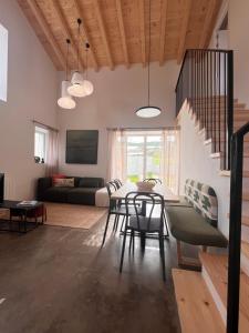 a dining room and living room with a table and chairs at La Casuca del Olivo - casa con jardín cerca de Cabárceno y Santander in Ceceñas