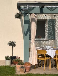 a patio with a table and chairs on a porch at La Casuca del Olivo - casa con jardín cerca de Cabárceno y Santander in Ceceñas