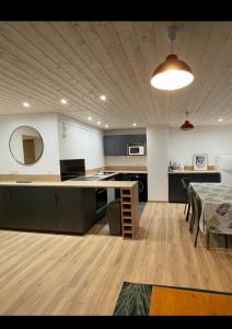 Großes Zimmer mit einer Küche und einem Tisch mit Stühlen. in der Unterkunft T3cab-Peyragudes-61m2-8pers in Germ