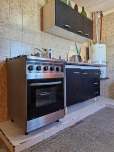una cocina con estufa y fregadero en Hospedaje el buen descanso, en Gobernador Gregores 4 fotos más