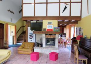 a living room with a fireplace and a piano at Le moulin de chaume in Champagné-Saint-Hilaire