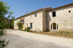 an external view of a stone building with a driveway at Le moulin de chaume in Champagné-Saint-Hilaire