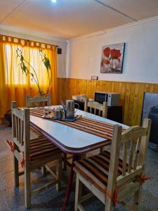 Una mesa de comedor con dos sillas de madera y una mesa de comedor. en Hospedaje el buen descanso, en Gobernador Gregores