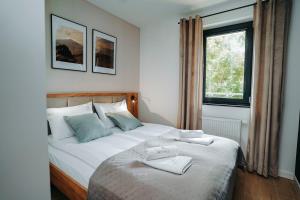 a bedroom with a bed with two towels on it at Althea Ustrzyki Apartmants in Skorka +23 photos
