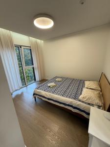 a bedroom with a bed and a large window at Birstonas Holidays Apartment in Birštonas