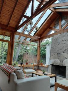 - un salon avec une grande cheminée en pierre dans l'établissement Casa céntrica SONNE San Martín de los Andes, à San Martín de los Andes
