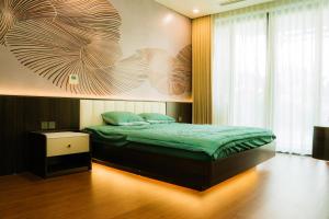 Kon Rung (1)Mohu Villa - HA11 Venus Resort By Flamingo Đại Lải的卧室里有一张床，墙上挂着一幅画 更多27张照片