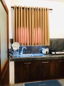 a kitchen with a sink and a shower curtain at Hiriketiya Green Haven Villa in Dickwella +2 photos
