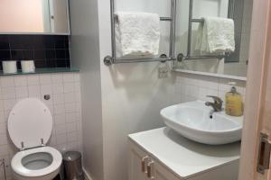 een badkamer met een wit toilet en een wastafel bij London 1 Bed Apartment close to Barking Station in Barking +4 foto's