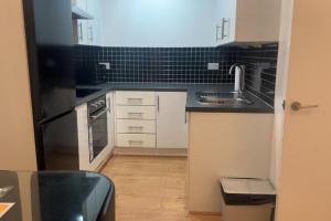 een keuken met een spoelbak en een aanrechtblad bij London 1 Bed Apartment close to Barking Station in Barking