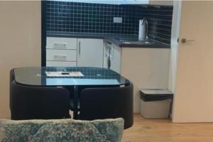 een tafel en stoelen in een keuken met een wastafel bij London 1 Bed Apartment close to Barking Station in Barking