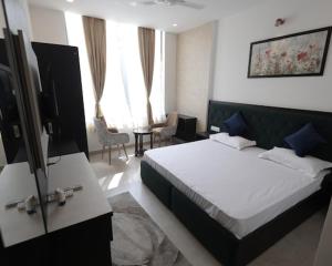KurukshetraにあるHotel Rajshreeのベッドとテレビがあるホテルの部屋