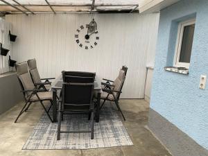 a table with chairs and a clock on a wall at Unterm-Felsen in Bad Überkingen +8 photos
