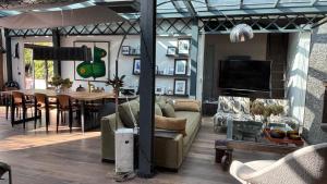 Maison contemporaine Centre DEAUVILLE - " 3 NUITS MINIMUM" في دوفيل: غرفة معيشة مع أرائك وغرفة طعام