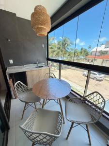 Una mesa y sillas en una habitación con una ventana grande. en Kauai 201 Tamandaré, en Tamandaré