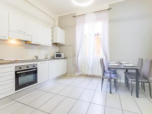 莱科Riva RealEstate - Como Lake的配有白色橱柜、桌子和椅子的厨房