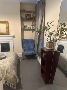 Un dormitorio con una cama, un espejo y una silla. en Effra Mansions, en Londres