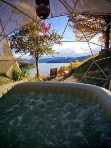 a hot tub with a view of the water at Moon Lake Bicaz - Casa Imero in Buhalniţa