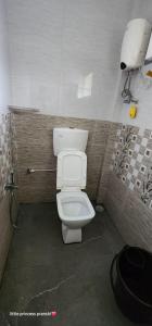 a bathroom with a white toilet in a stall at Leela Grove Cottages Gokarna in Gokarna