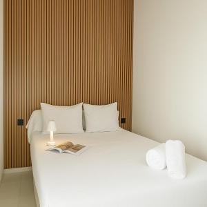 a bed with two towels and a book on it at Holidays Rincón Vista Mar PL4 in Empuriabrava