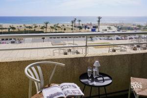 a balcony with a table and chairs with a view of the beach at Holidays Rincón Vista Mar PL4 in Empuriabrava