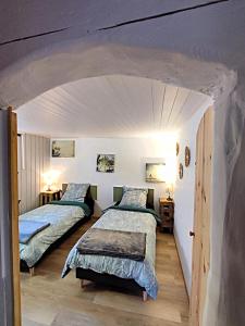two beds in a room with an archway at Villa Garona avec billard proche Pyrénées in Cazères