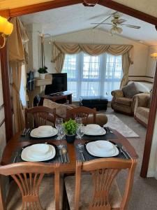 a dining room table with plates and glasses on it at i7 Millfields 6 Berth Luxury Caravan DG & GCH Familys Only And Lead Person Must Be Over 30 in Ingoldmells