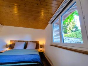 a bedroom with a bed and a large window at Villa Garona avec billard proche Pyrénées in Cazères