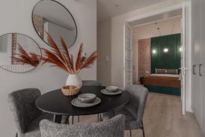 a dining room with a table with chairs and a mirror at Harbor Apartments - Aparthotel przy Rynku in Katowice
