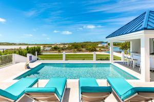 プロビデンシャレスにあるNew Unique Villa Blue Top! 2 Bedroom Waterfrontの長椅子と家のあるプール