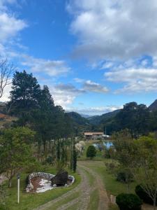 a dirt road in a field with a house in the distance at Pousada Casa Primitivus in Pedra Menina +123 photos