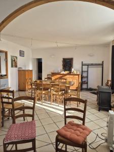 a room with chairs and tables and a kitchen at Au Diapason Chambres d'hôtes montagne in Auzet
