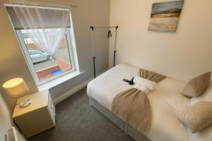 a small bedroom with a bed and a window at 3-BR Beachside Escape -Perfect for Families & Groups -Spacious & Cozy in Hawthorn
