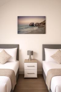 En eller flere senge i et værelse på Relaxing Beachside 3BR Stay -Ideal for Families & Group Getaways + 21 billeder