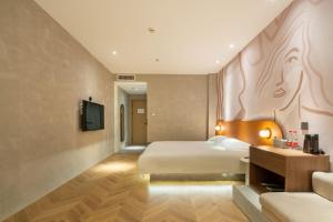 a hotel room with a bed and a television at Qiyu Hotel - Xian Bell Tower in Xi'an