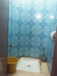 een blauw betegelde badkamer met een emmer en een toilet bij Budget private Room, Wifi in Inezgane