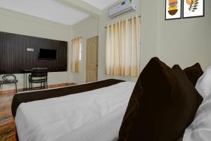 a bedroom with a bed and a table with a chair at Hotel O Symbiosis University Nagpur Formerly Royal Villa Inn in Nagpur +21 photos