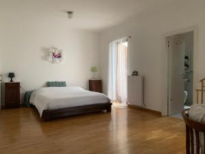 une chambre blanche avec un lit et un parquet dans l'établissement Villa Irim tra il mare e la montagna, 