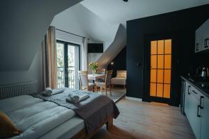 a bedroom with a bed and a kitchen and a table at Althea Ustrzyki Apartmants in Skorka
