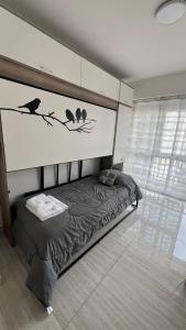 a bedroom with a bed with birds on the wall at Studio Arena y Sol - MDQ Güemes in Mar del Plata