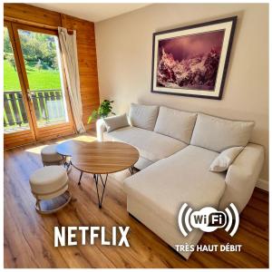 a living room with a white couch and a table at Appartement Champêtre - Terrasse, Vue & Parking by AlpenlySallanches in Domancy