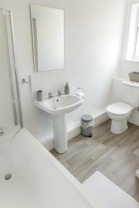 a white bathroom with a sink and a toilet at Near the Beach 3Bedroom Apartment WIFI Modern & Spacious Sleeps 6 in Hawthorn +19 photos