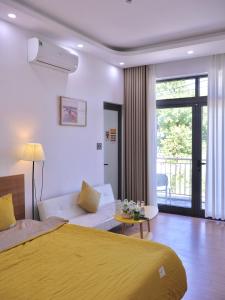 a bedroom with a yellow bed and a living room at Nắng Homestay Huế in Hue +35 photos