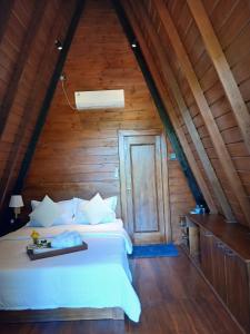 a bedroom with a white bed with a wooden ceiling at Habarana Chena Hut - Air conditioning Private Cabana with Balcony in Habarana +35 photos