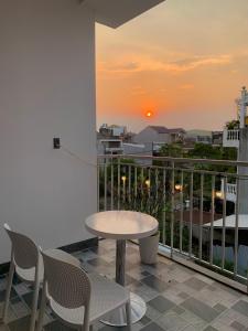a balcony with a table and chairs and a sunset at Nắng Homestay Huế in Hue