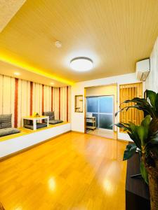 una sala de estar con un sofá y una mesa en 晶 距离车站步行5分钟 关西机场难波心斋桥直达 5 bedroom最多可住13人 超大客厅大电视有Netflix, en Osaka