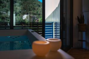 a bathroom with a tub and a large window at Junior Suite con spa privata disponibile su richiesta in Maso