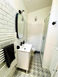 a bathroom with a sink and a toilet and a mirror at Le Petit Réaumur - Coeur de ville in La Rochelle
